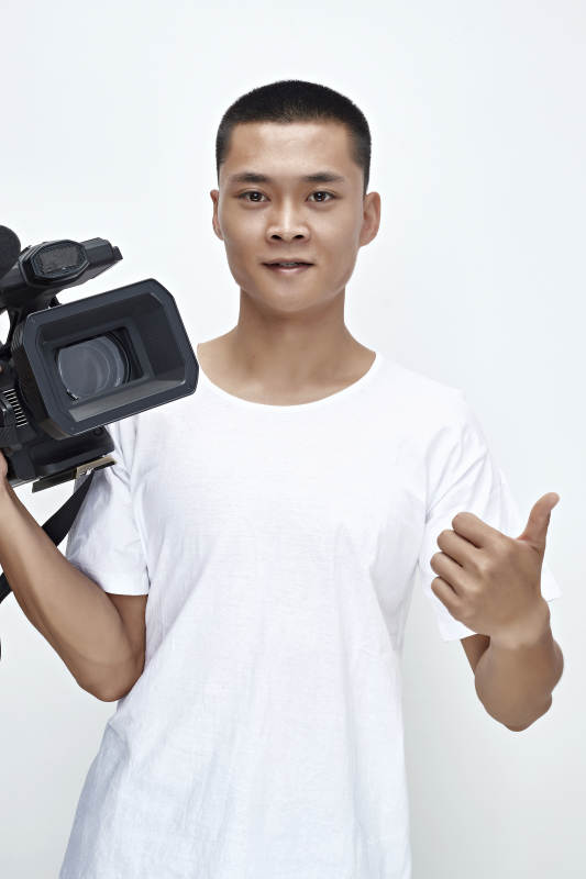 白色背景下手持摄像机进行录制拍摄的摄像师图片