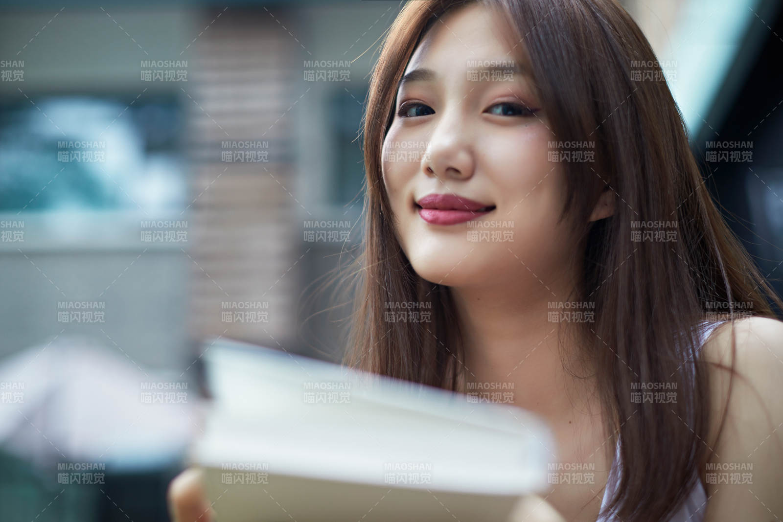 院子里坐在长椅上阅读书籍的亚洲长发少女图片