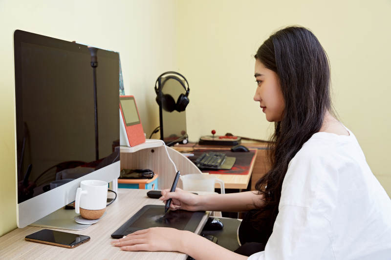 居家在电脑前创作插画的年轻美女图片