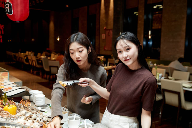 在酒店自助餐厅大吃特吃的亚洲可爱闺蜜少女图片