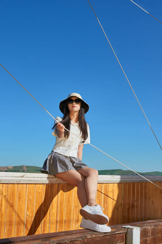 在湖畔木制帆船上的亚洲美女图片