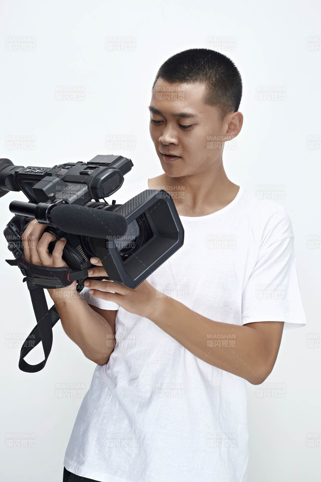 白色背景下手持摄像机进行录制拍摄的摄像师图片
