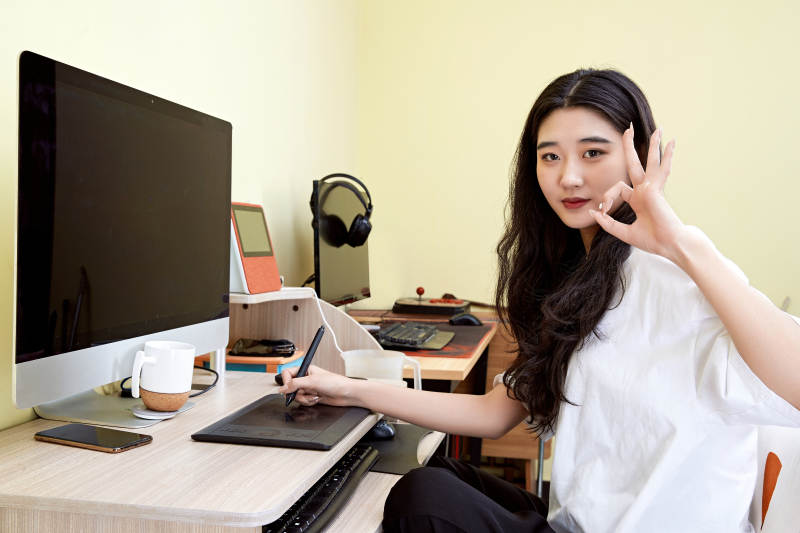 居家在电脑前创作插画的年轻美女图片