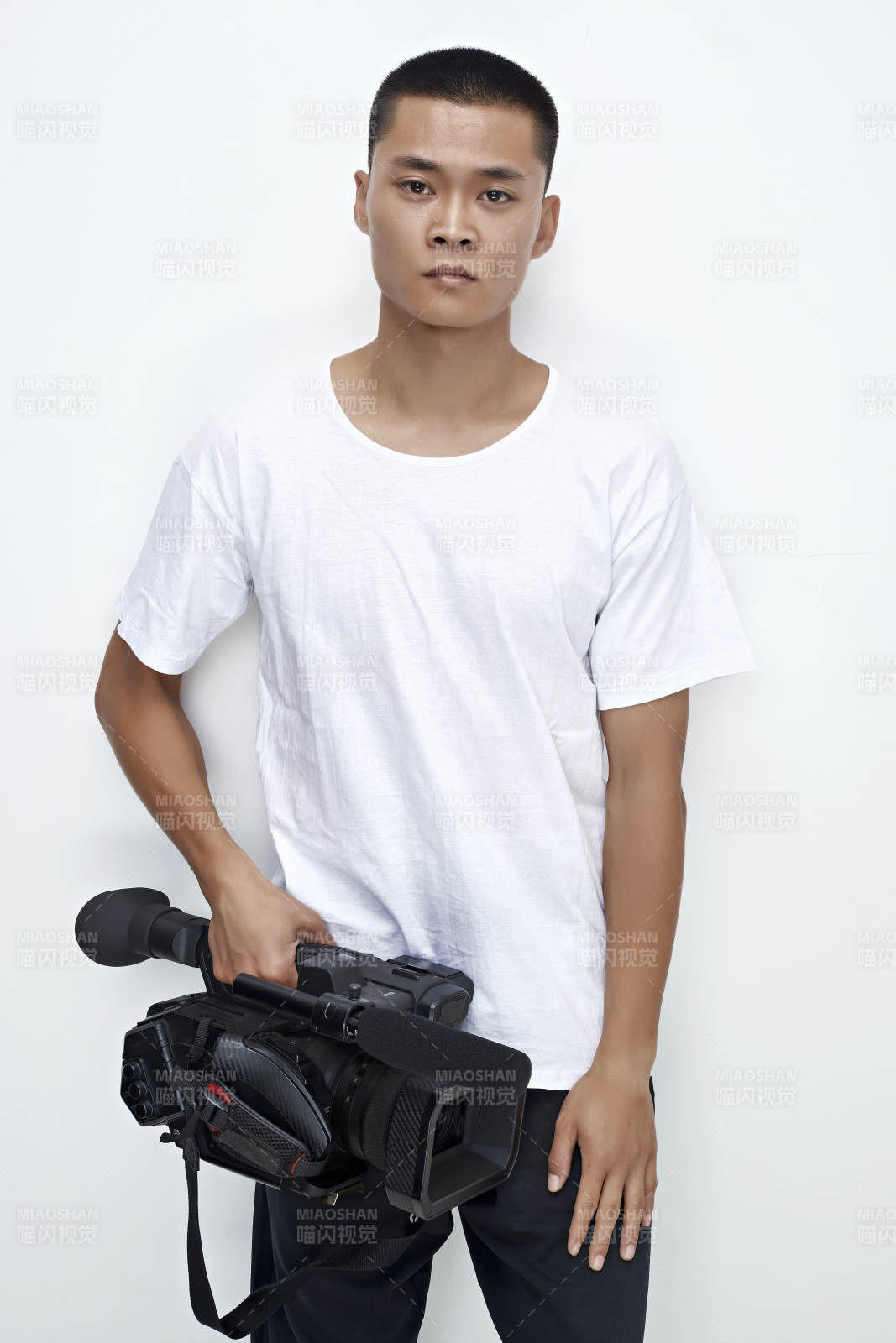 白色背景下手持摄像机进行录制拍摄的摄像师图片