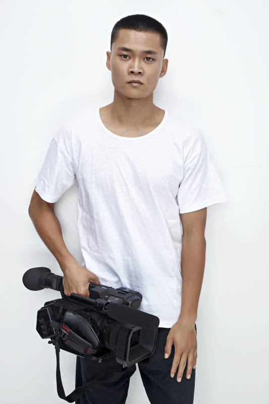 白色背景下手持摄像机进行录制拍摄的摄像师图片