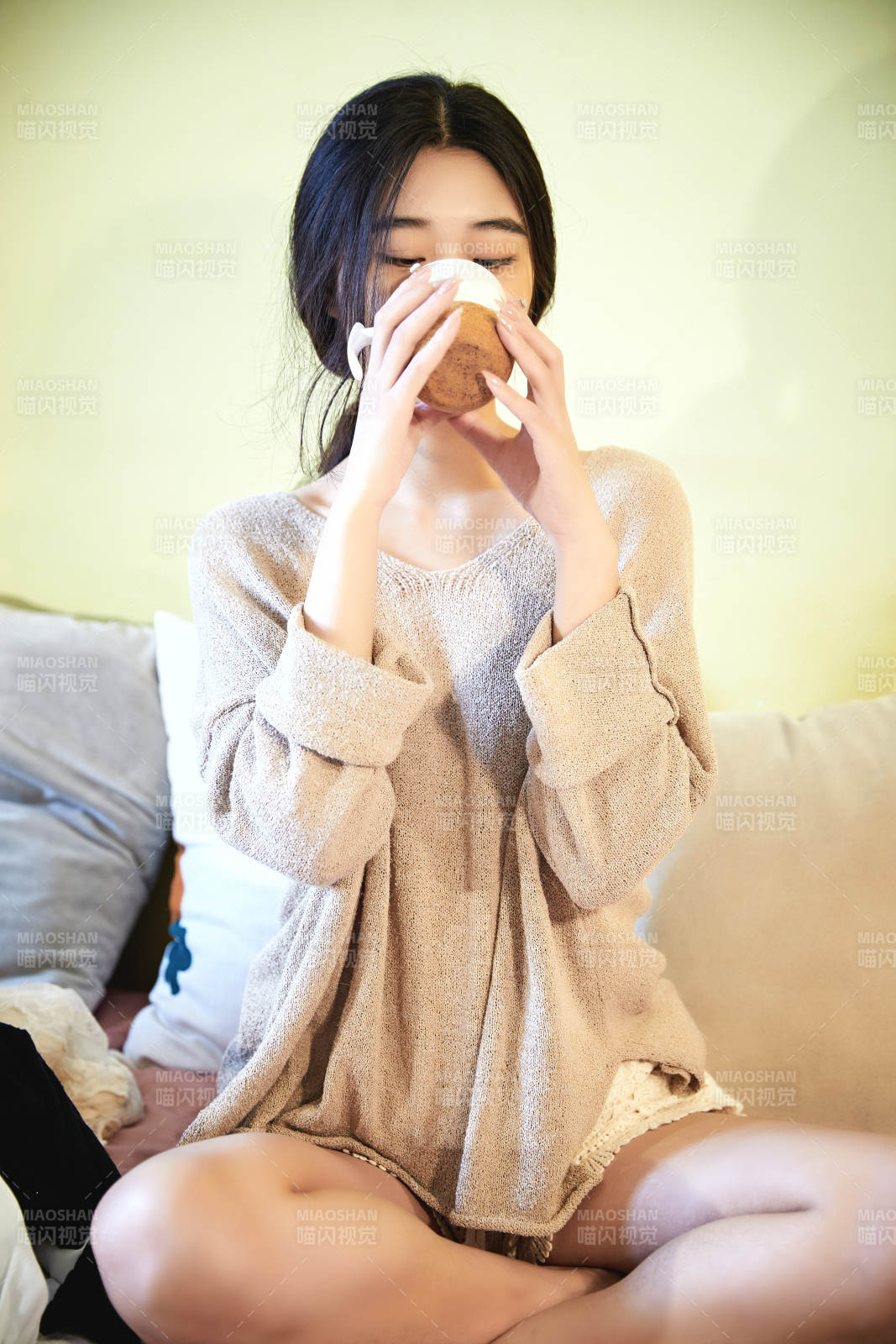 在沙发床上整理行装的年轻亚洲女性图片