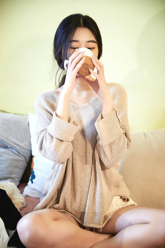 在沙发床上整理行装的年轻亚洲女性图片