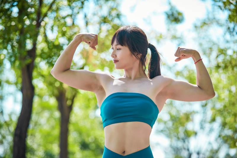 湖畔公园做瑜伽动作的亚洲年轻女性图片