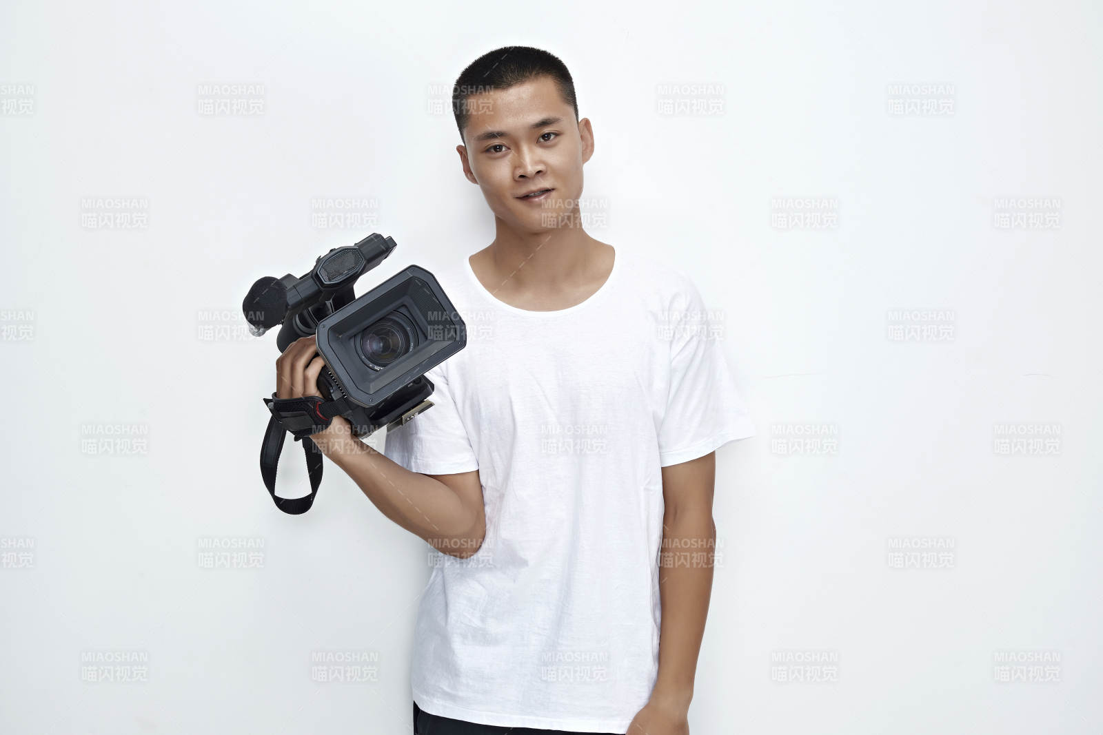 白色背景下手持摄像机进行录制拍摄的摄像师图片