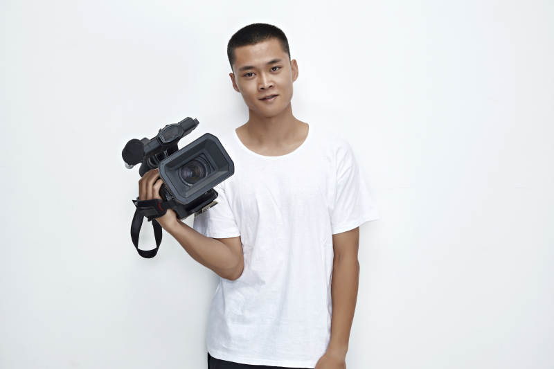 白色背景下手持摄像机进行录制拍摄的摄像师图片