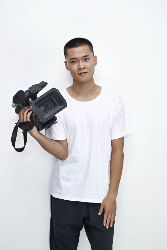 白色背景下手持摄像机进行录制拍摄的摄像师图片