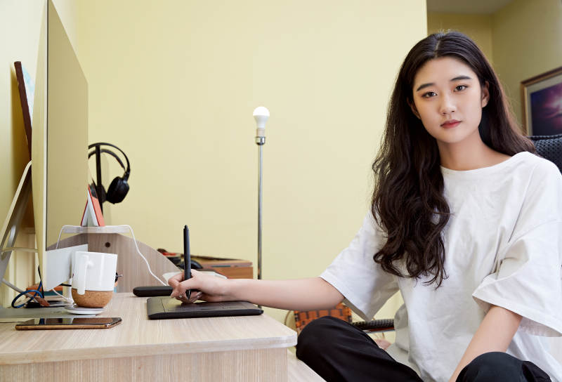 居家在电脑前创作插画的年轻美女图片
