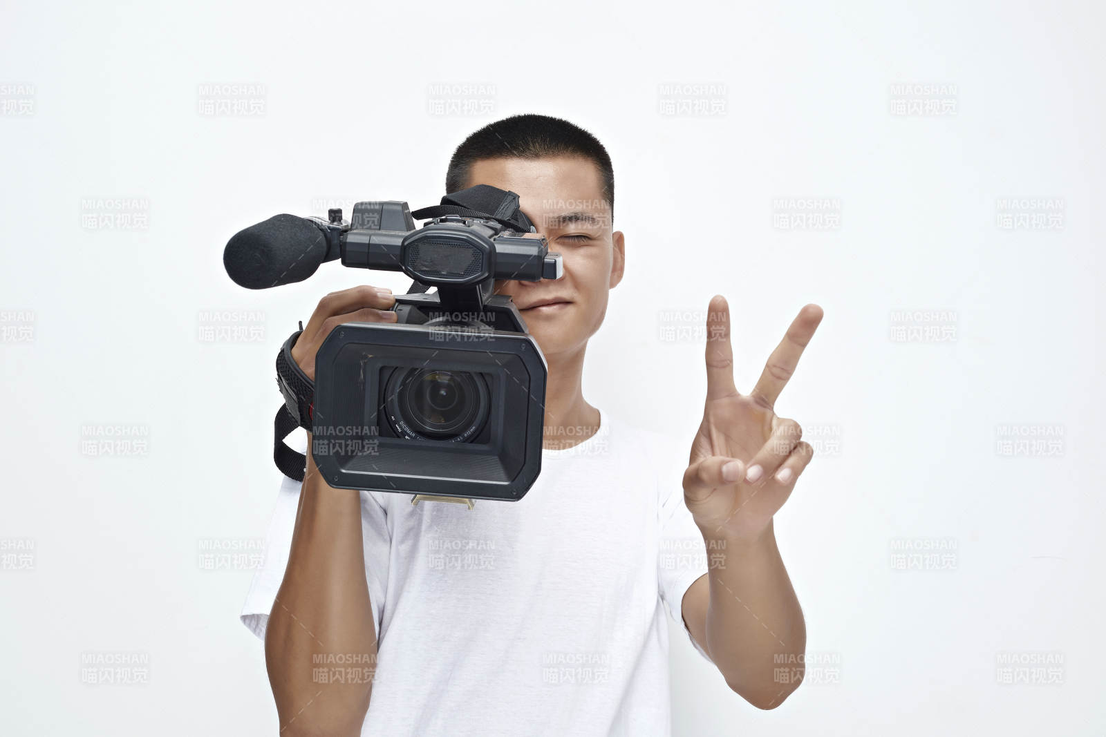 白色背景下手持摄像机进行录制拍摄的摄像师图片