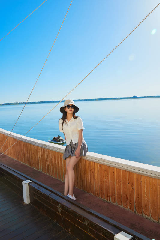 在湖畔木制帆船上的亚洲美女图片