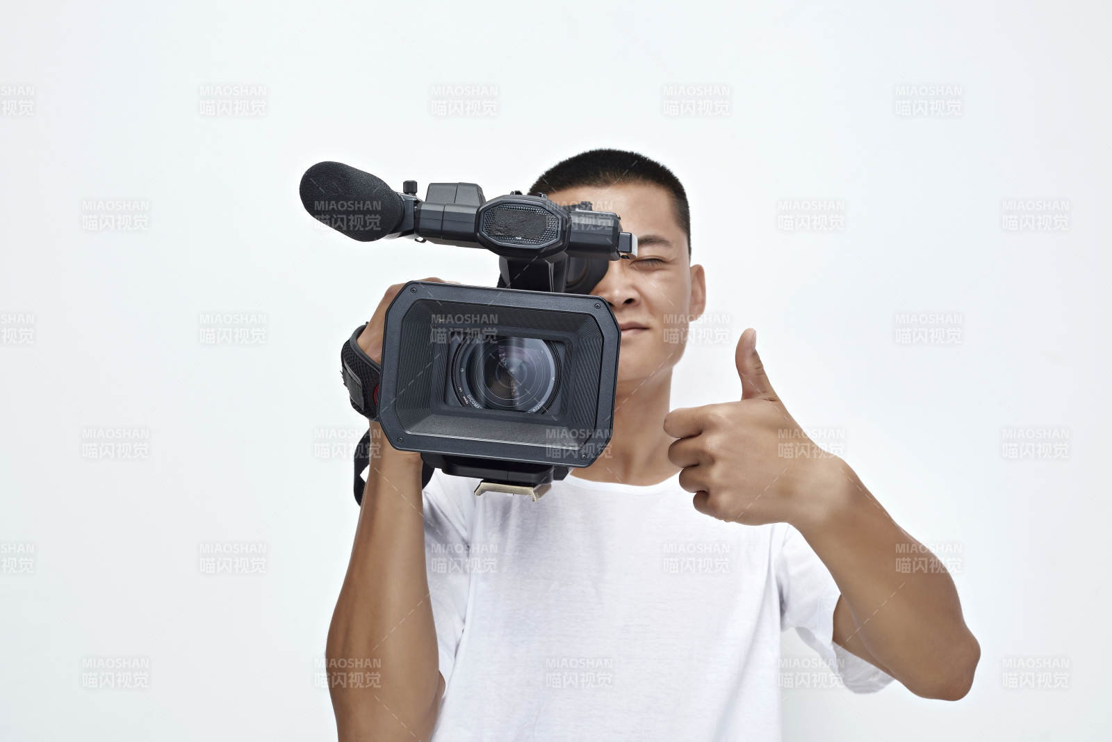 白色背景下手持摄像机进行录制拍摄的摄像师图片