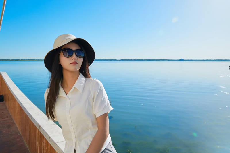 在湖畔木制帆船上的亚洲美女图片