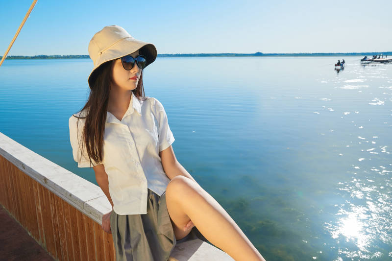 在湖畔木制帆船上的亚洲美女图片