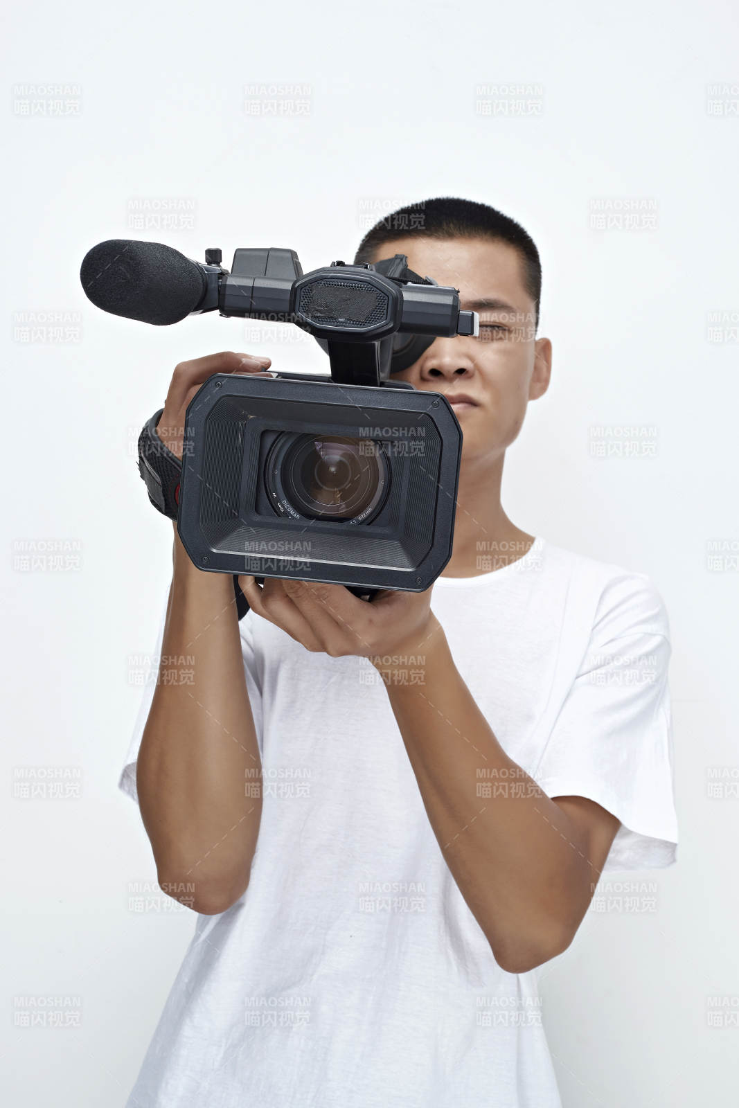白色背景下手持摄像机进行录制拍摄的摄像师图片