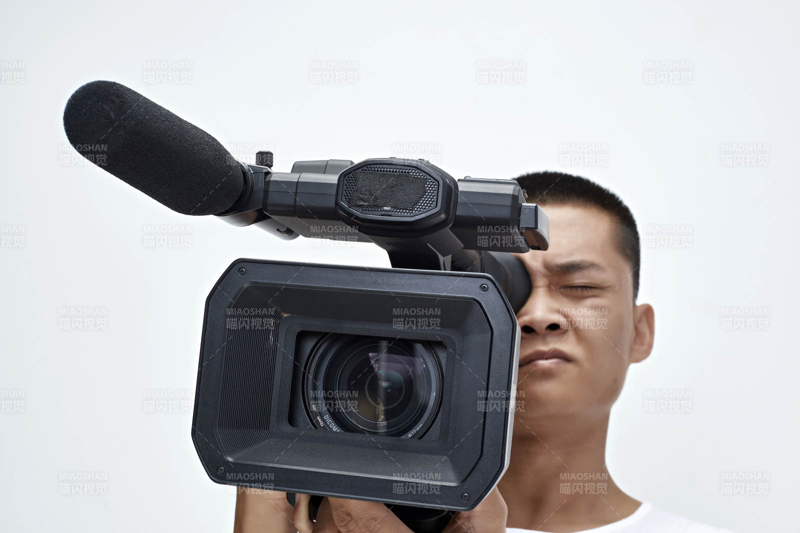 白色背景下手持摄像机进行录制拍摄的摄像师图片