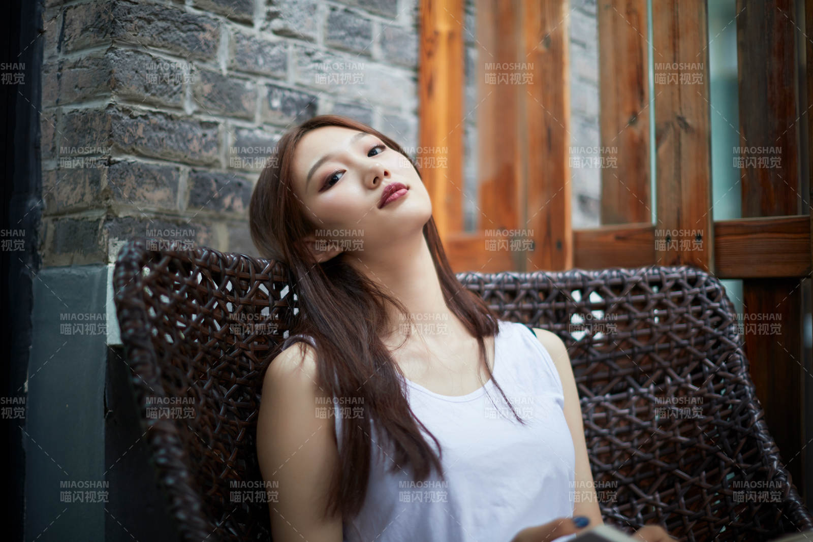 院子里坐在长椅上阅读书籍的亚洲长发少女图片