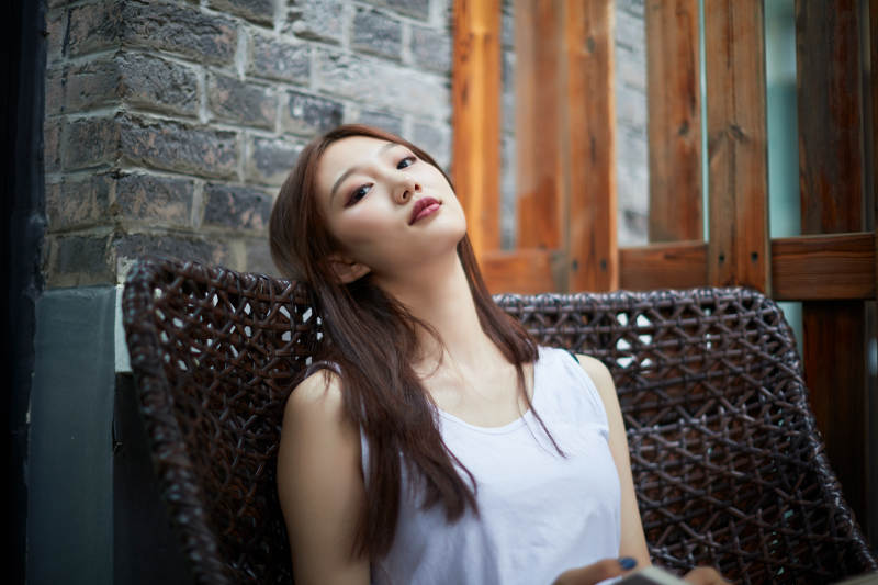 院子里坐在长椅上阅读书籍的亚洲长发少女图片