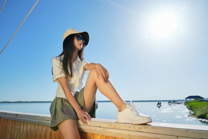 在湖畔木制帆船上的亚洲美女图片