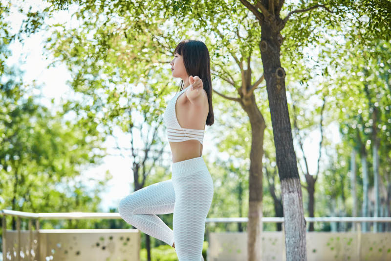 湖畔公园做瑜伽动作的亚洲年轻女性图片