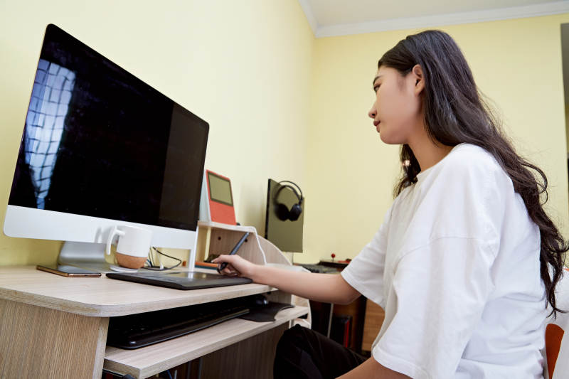 居家在电脑前创作插画的年轻美女图片