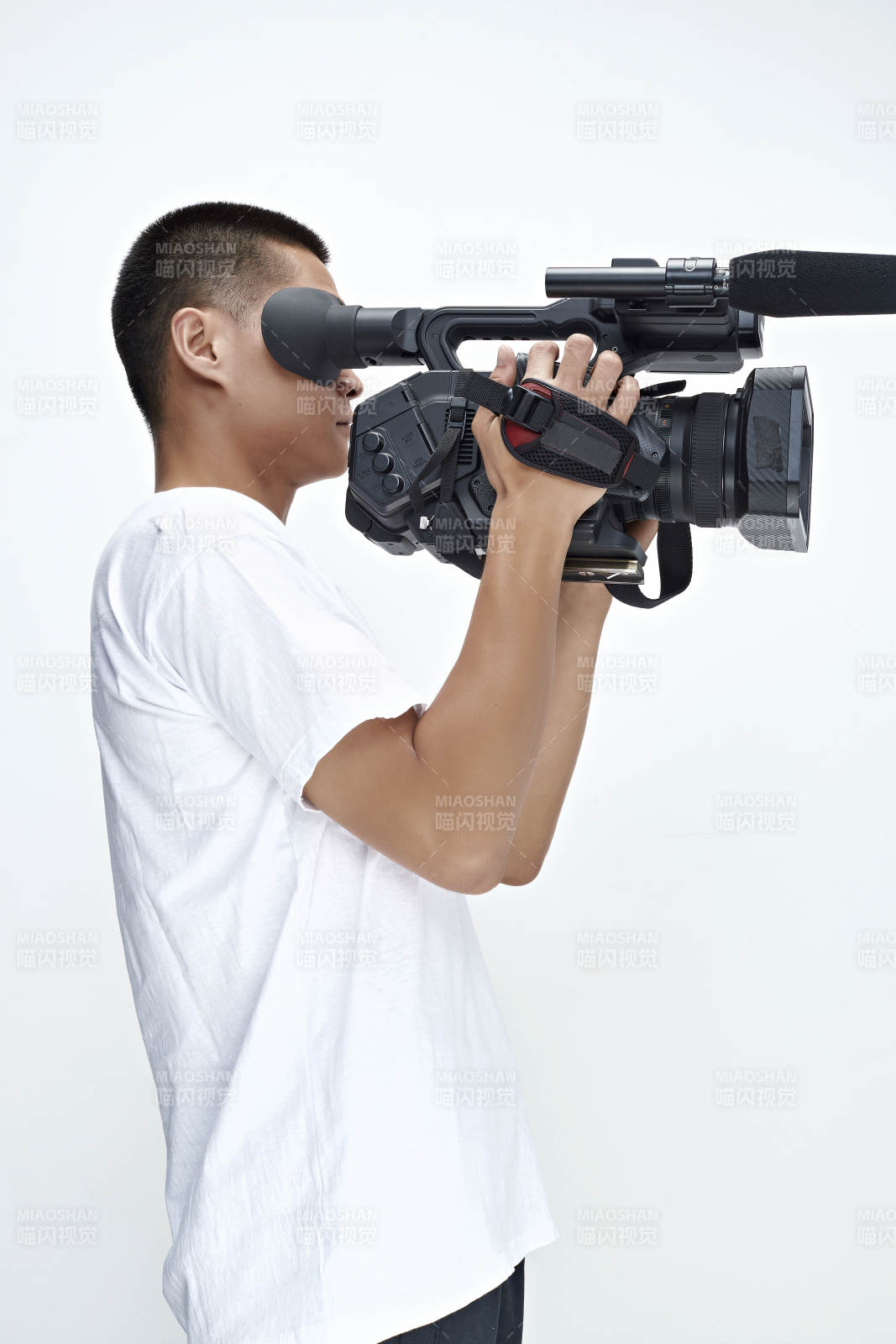 白色背景下手持摄像机进行录制拍摄的摄像师图片
