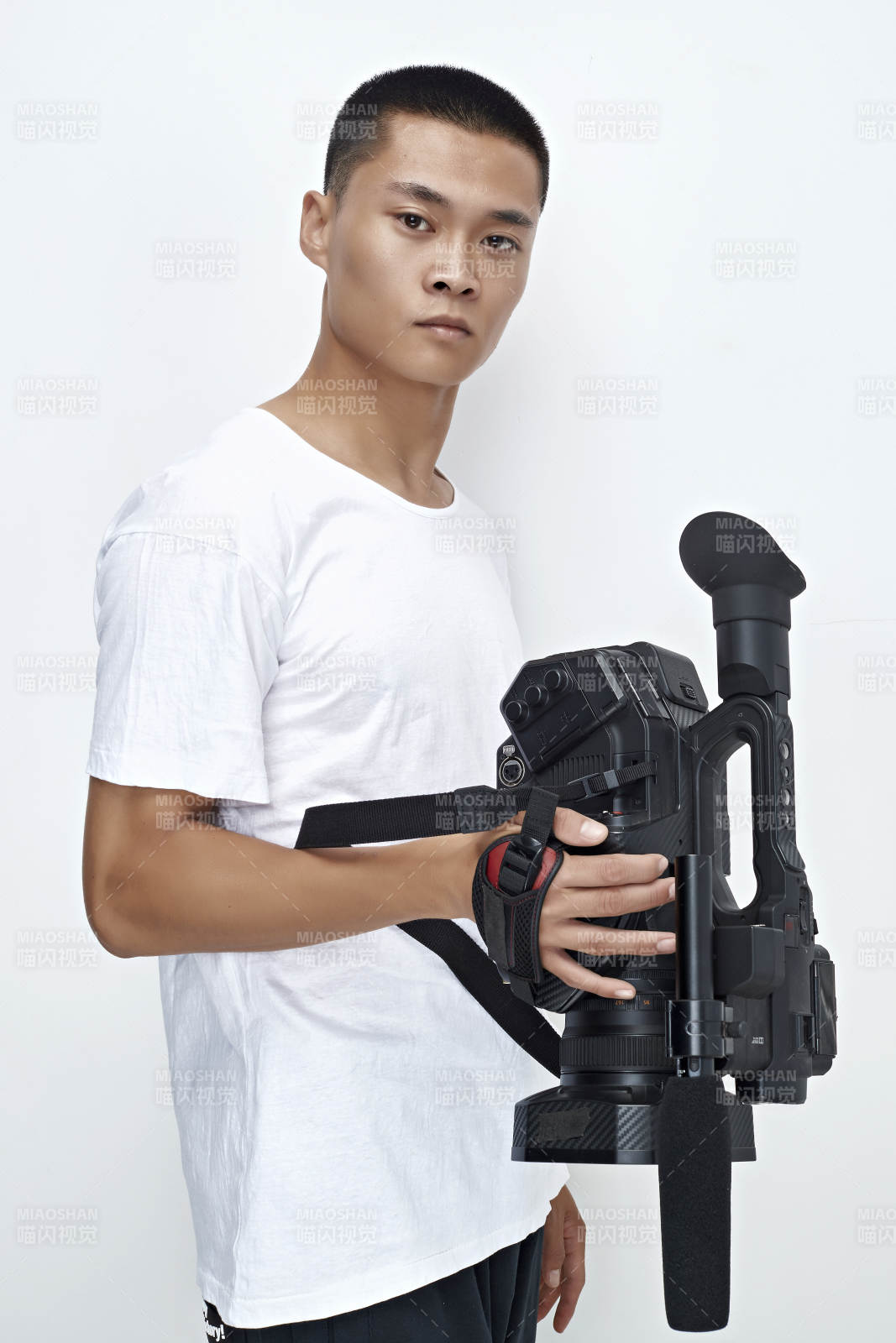 白色背景下手持摄像机进行录制拍摄的摄像师图片