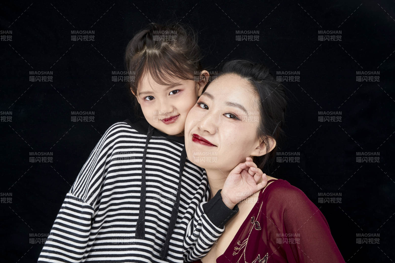 黑色背景的美丽妈妈与可爱女儿亲子人像图片