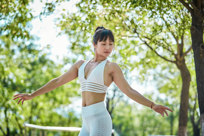 湖畔公园做瑜伽动作的亚洲年轻女性图片