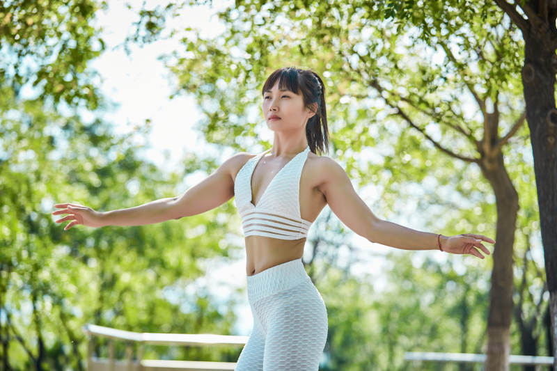 湖畔公园做瑜伽动作的亚洲年轻女性图片