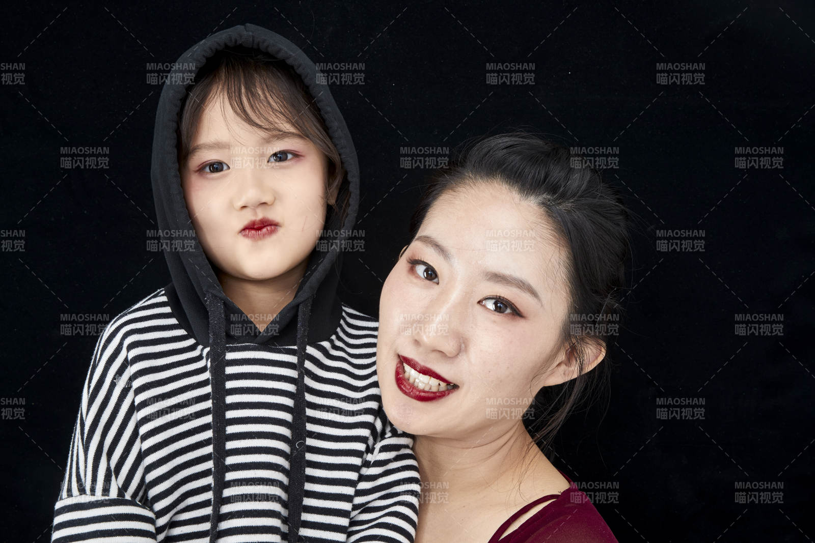 黑色背景的美丽妈妈与可爱女儿亲子人像图片