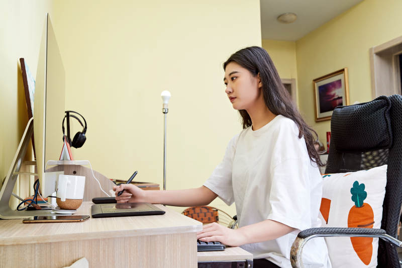 居家在电脑前创作插画的年轻美女图片