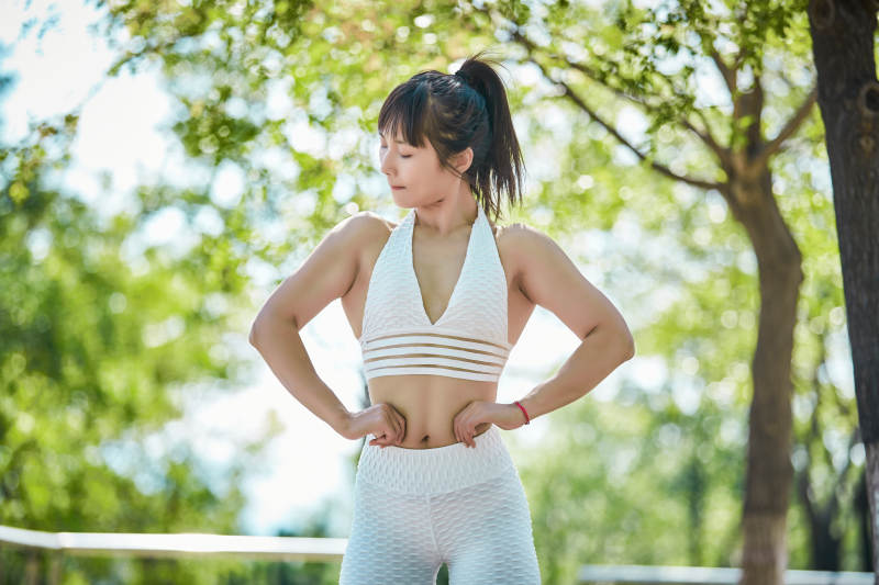 湖畔公园做瑜伽动作的亚洲年轻女性图片