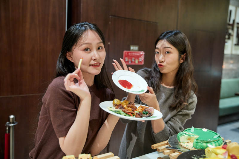 在酒店自助餐厅大吃特吃的亚洲可爱闺蜜少女图片