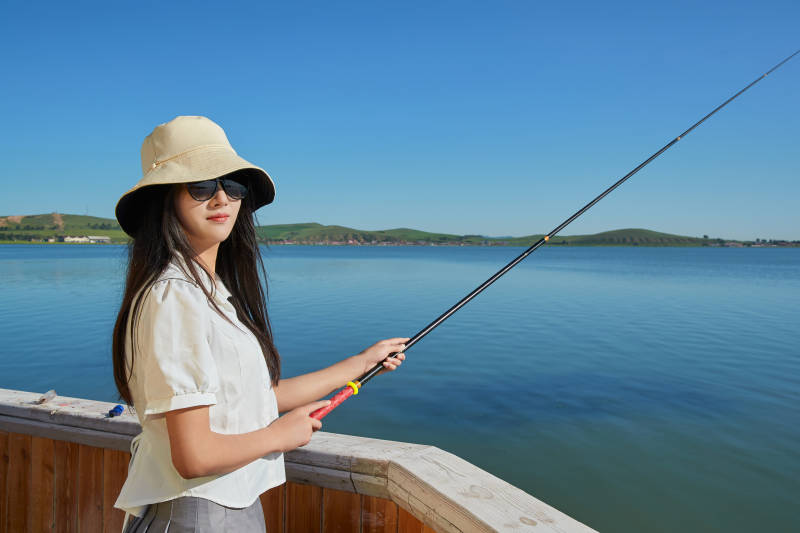 在湖畔木制帆船上的亚洲美女图片