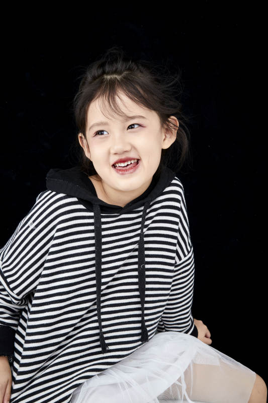 黑色背景的调皮可爱的亚洲小女孩儿童图片