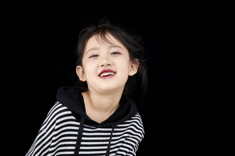 黑色背景的调皮可爱的亚洲小女孩儿童图片