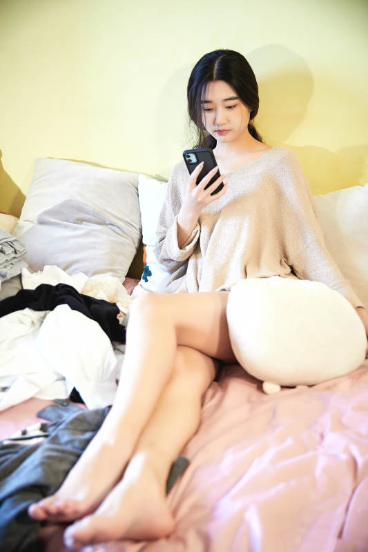 在沙发床上整理行装的年轻亚洲女性图片