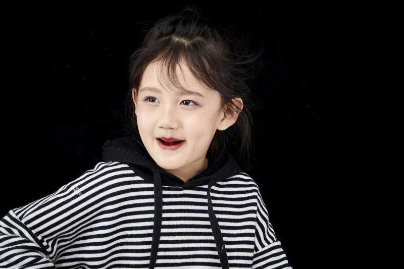 黑色背景的调皮可爱的亚洲小女孩儿童图片