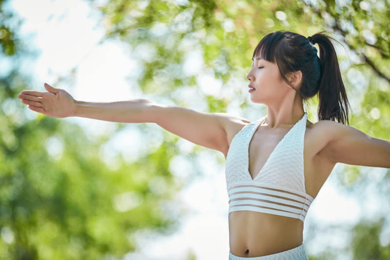 湖畔公园做瑜伽动作的亚洲年轻女性图片