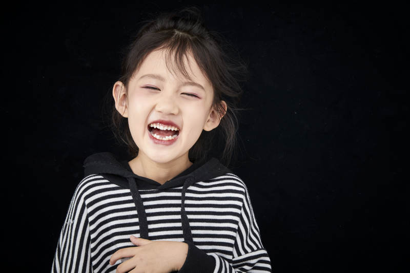 黑色背景的调皮可爱的亚洲小女孩儿童图片