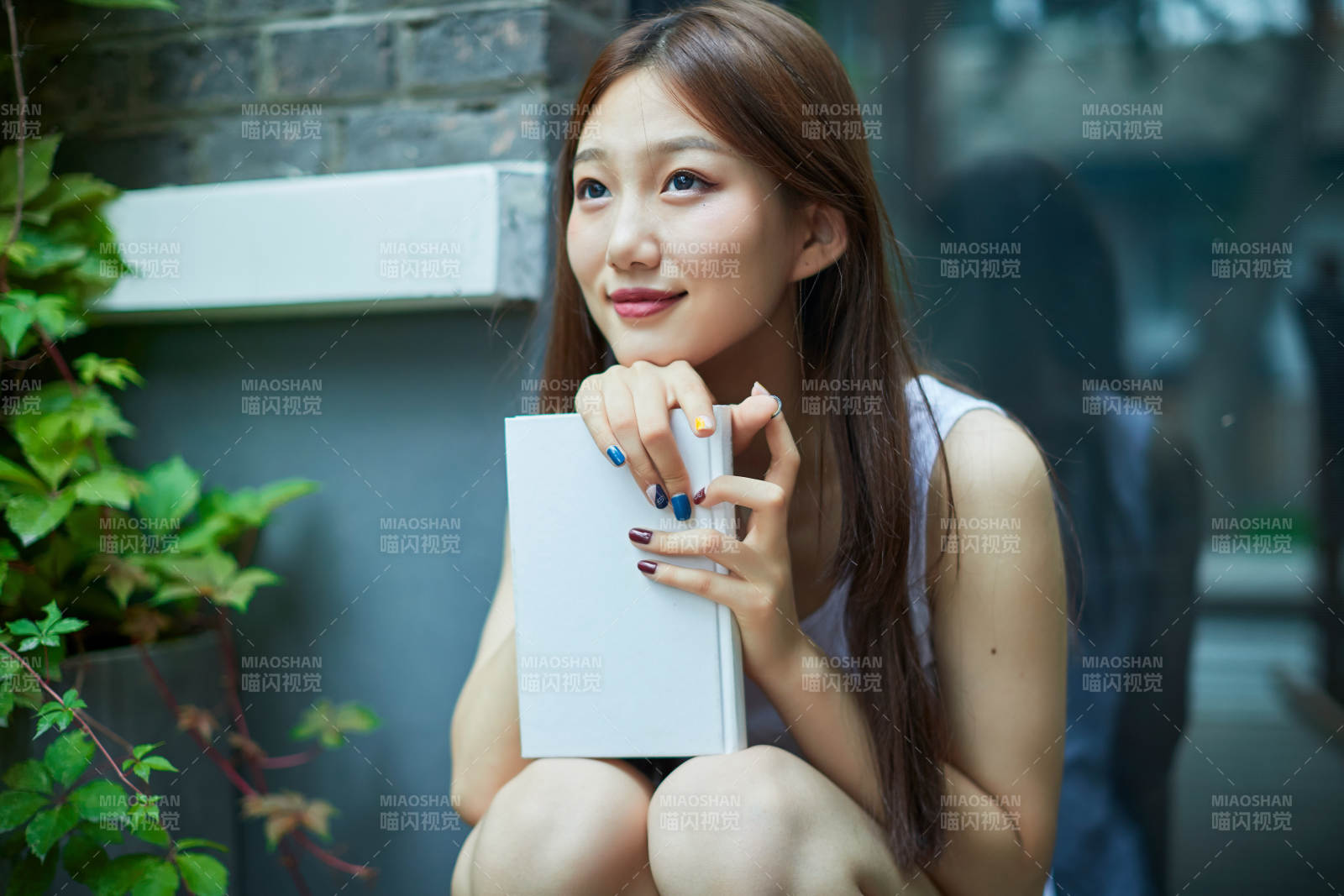 院子里坐在长椅上阅读书籍的亚洲长发少女图片