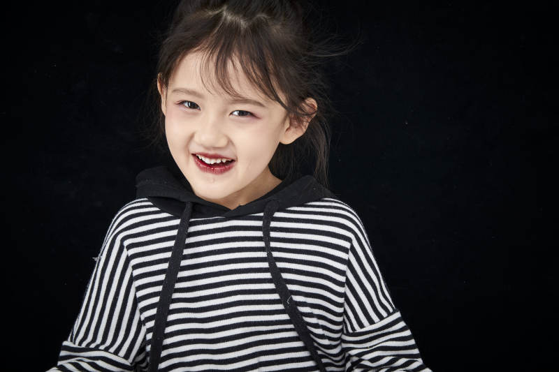 黑色背景的调皮可爱的亚洲小女孩儿童图片