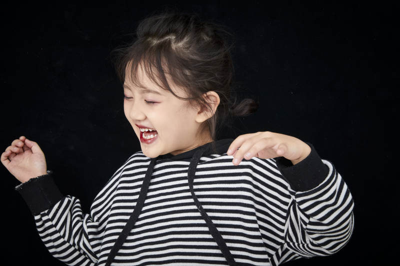 黑色背景的调皮可爱的亚洲小女孩儿童图片