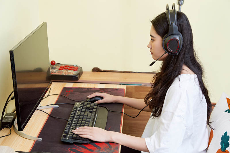 在家里坐在椅子上打游戏的美丽女孩图片