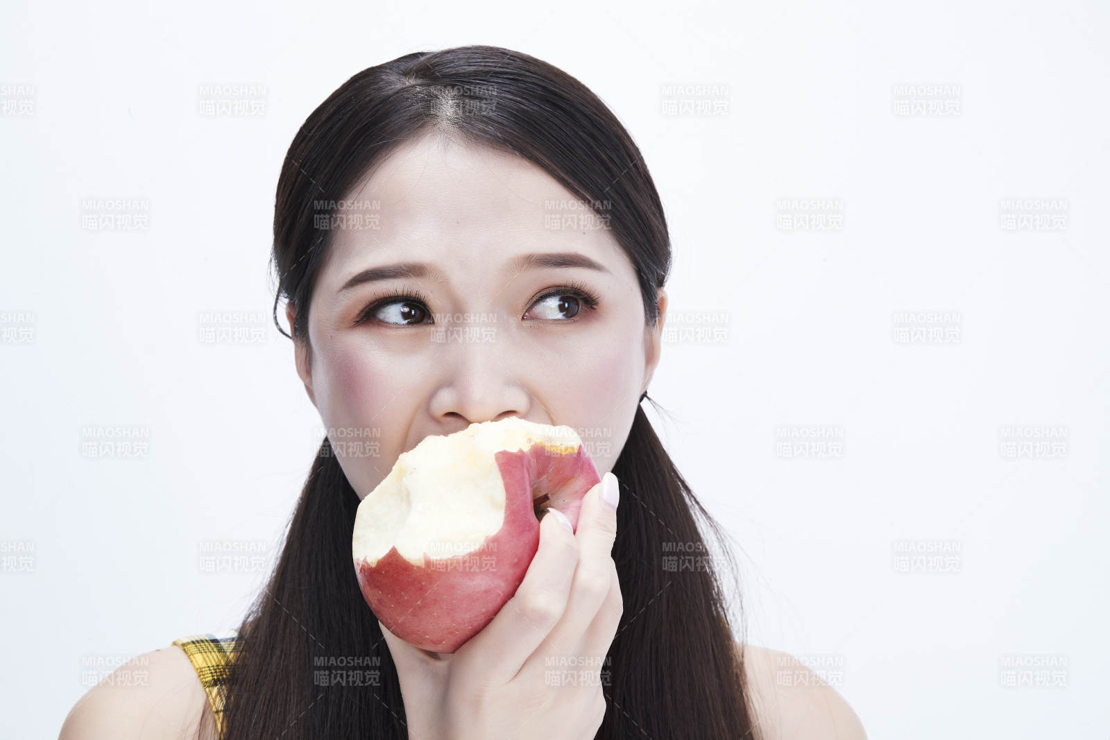 手拿苹果身穿格子吊带裙的亚洲可爱少女人像图片