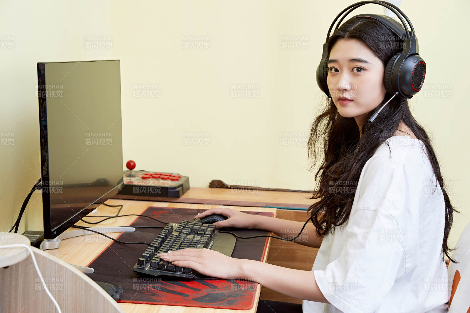 在家里坐在椅子上打游戏的美丽女孩图片